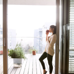 woman standing at open patio window